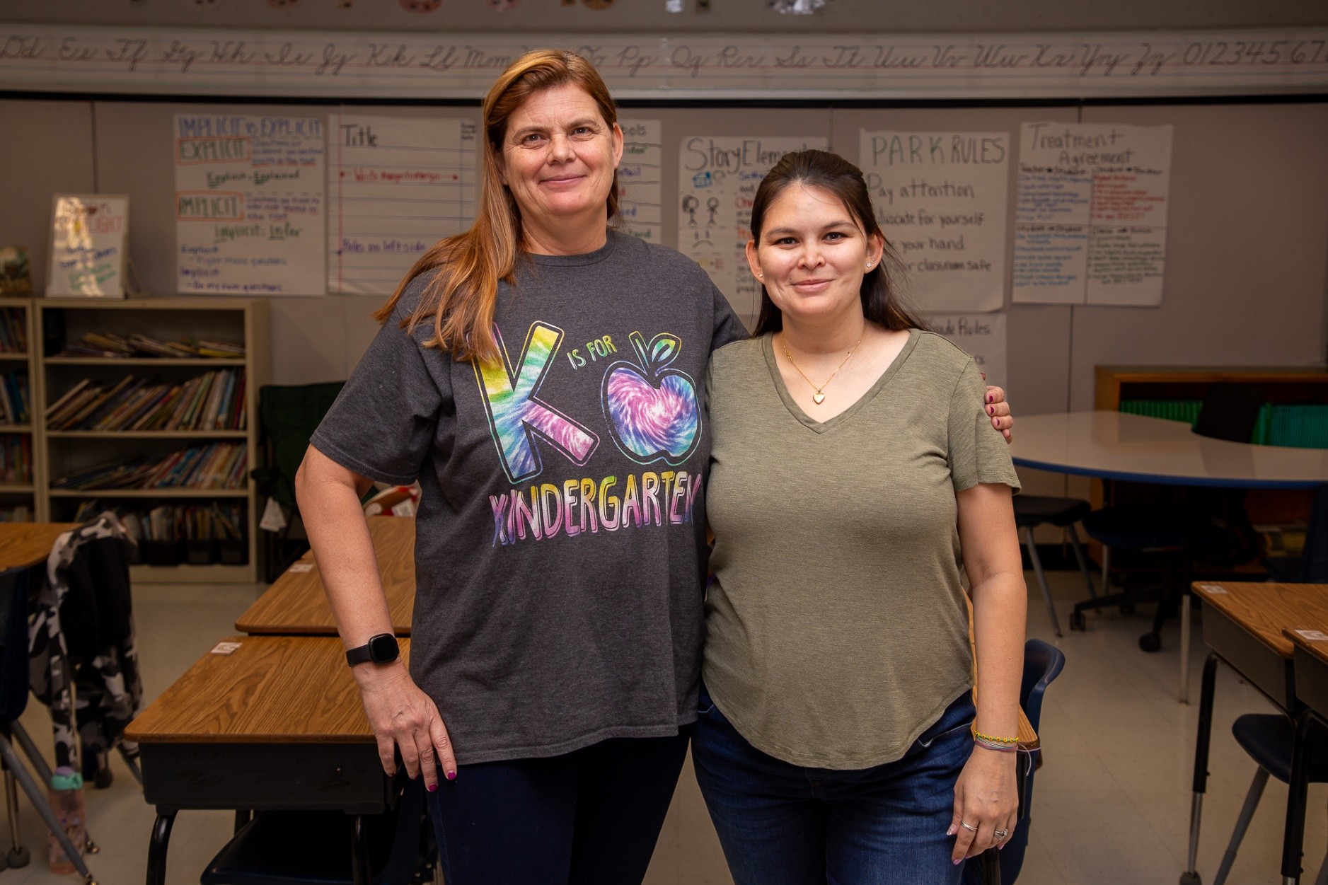 Dionne and Leah Fernandez pose in a classroom